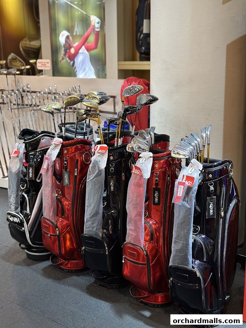 A display of shiny red and black golf bags with clubs inside at Pan-West Honma.