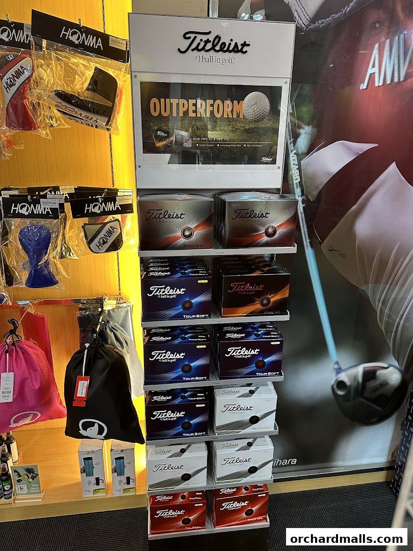 A display of Titleist golf balls and Honma golf accessories.