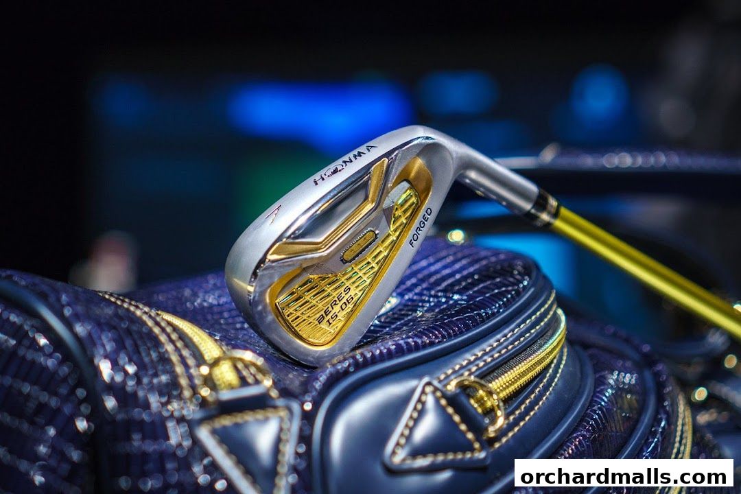 A close-up of a luxurious Honma golf club with gold accents resting on a matching golf bag.