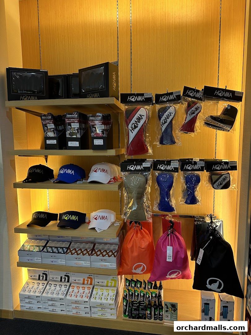 A display of golf accessories including headcovers, caps, bags, and golf balls from Honma.