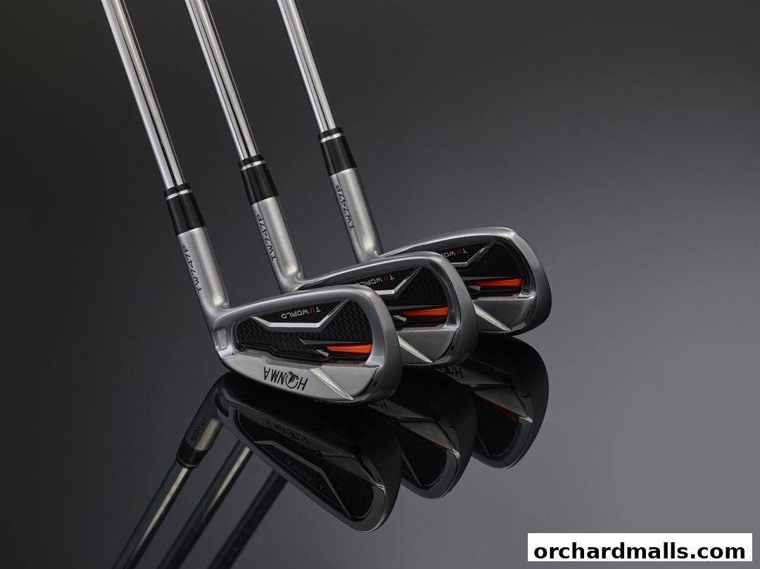Three Honma TW747P golf irons displayed on a reflective surface.