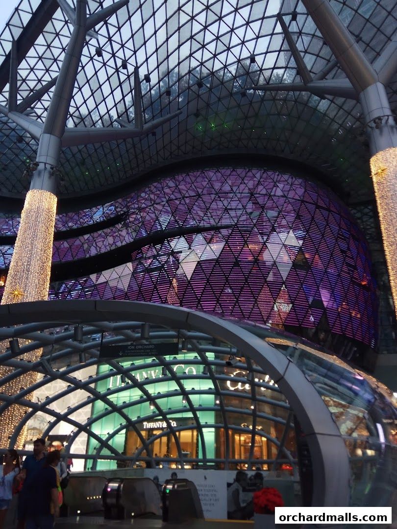 Exterior view of ION Orchard mall with Tiffany & Co. store and illuminated architectural features.