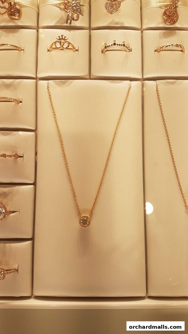 A display of Pandora jewelry, featuring rings and a rose gold necklace with a diamond pendant.
