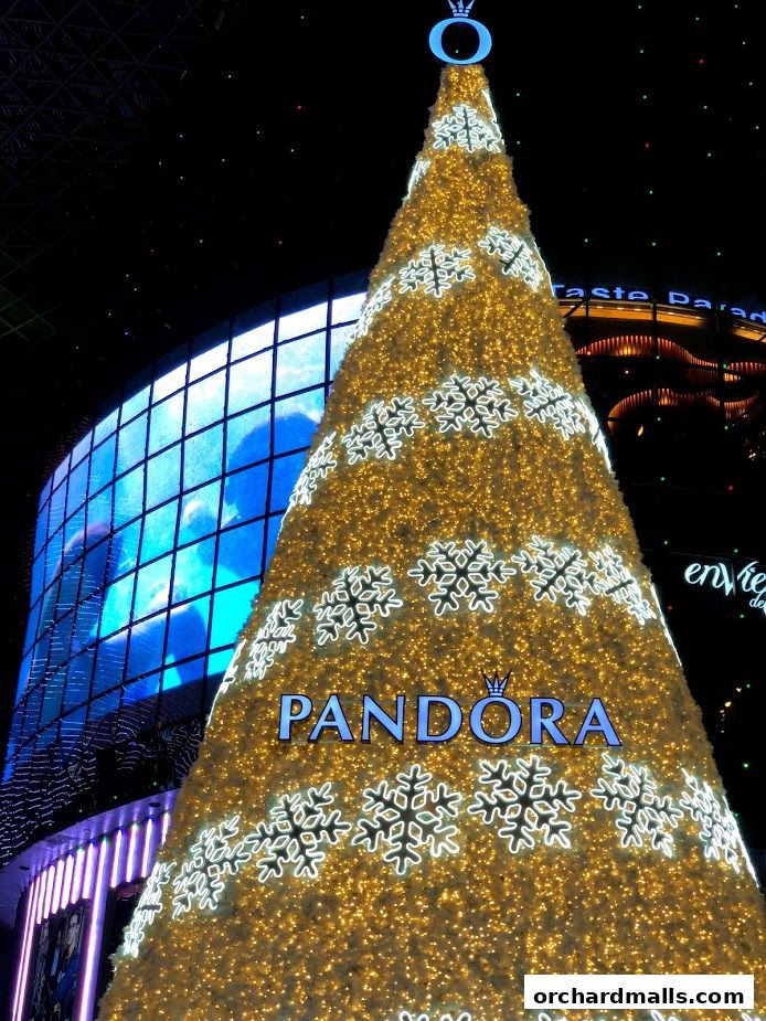A large, illuminated Christmas tree with the Pandora logo and snowflake decorations.