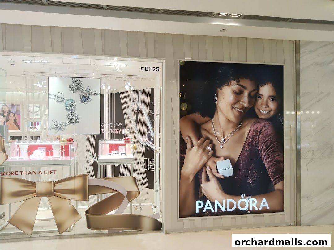 Pandora store window display featuring jewelry and a campaign image of a mother and child.
