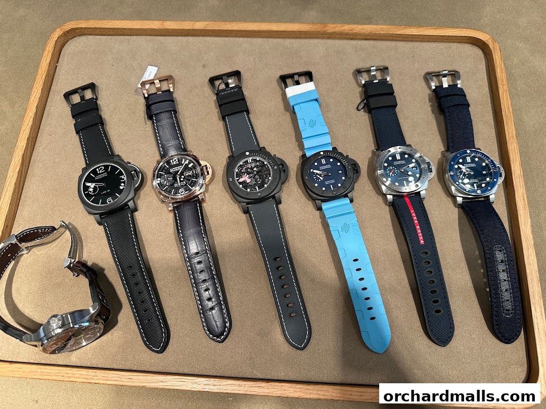 A collection of luxury Panerai watches displayed on a wooden tray.