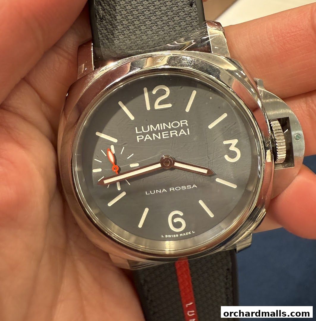 A close-up shot of a Panerai Luminor Luna Rossa watch with a grey dial and black strap.
