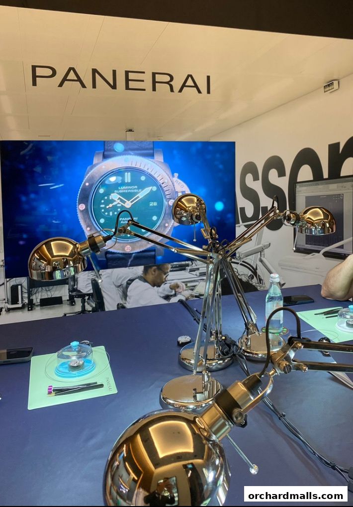 Panerai logo above a large screen displaying a watch, with workbenches and lamps.