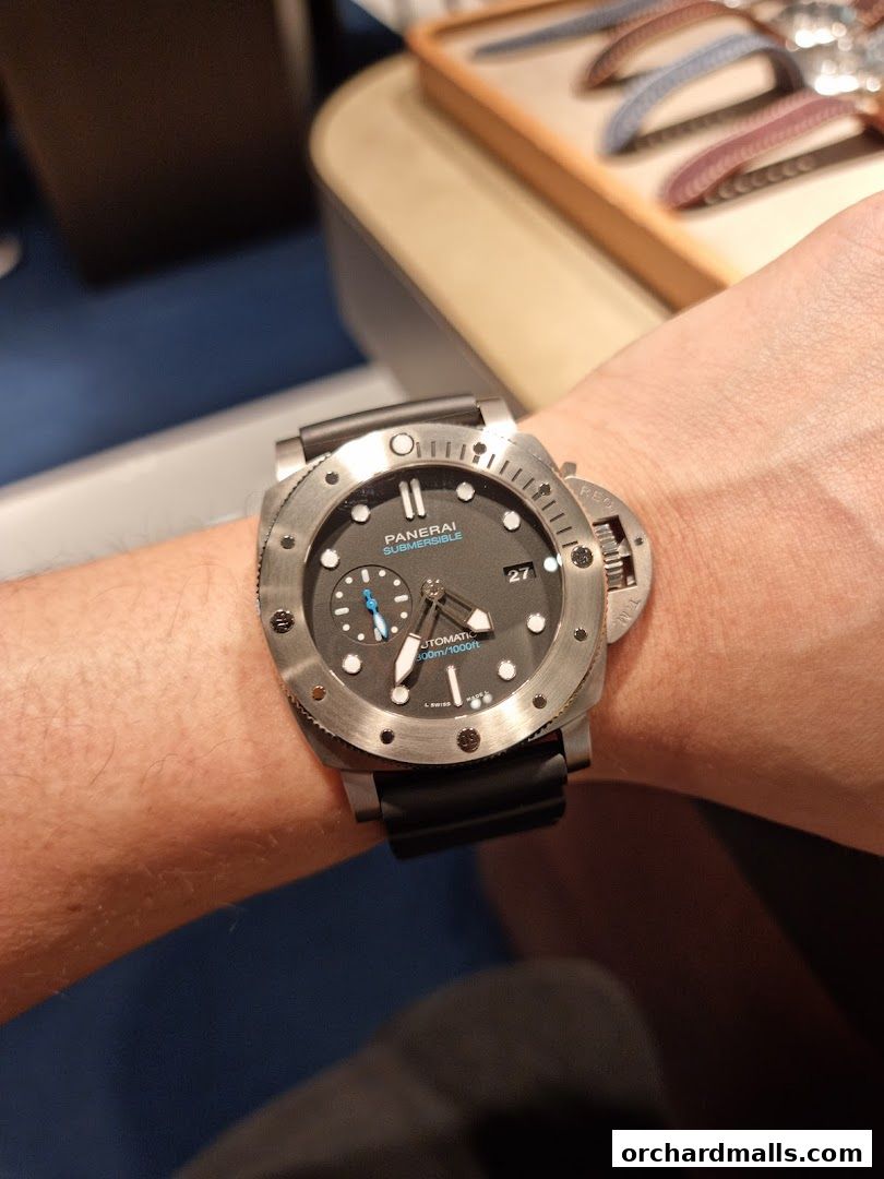 A close-up shot of a Panerai Submersible watch on a person's wrist.