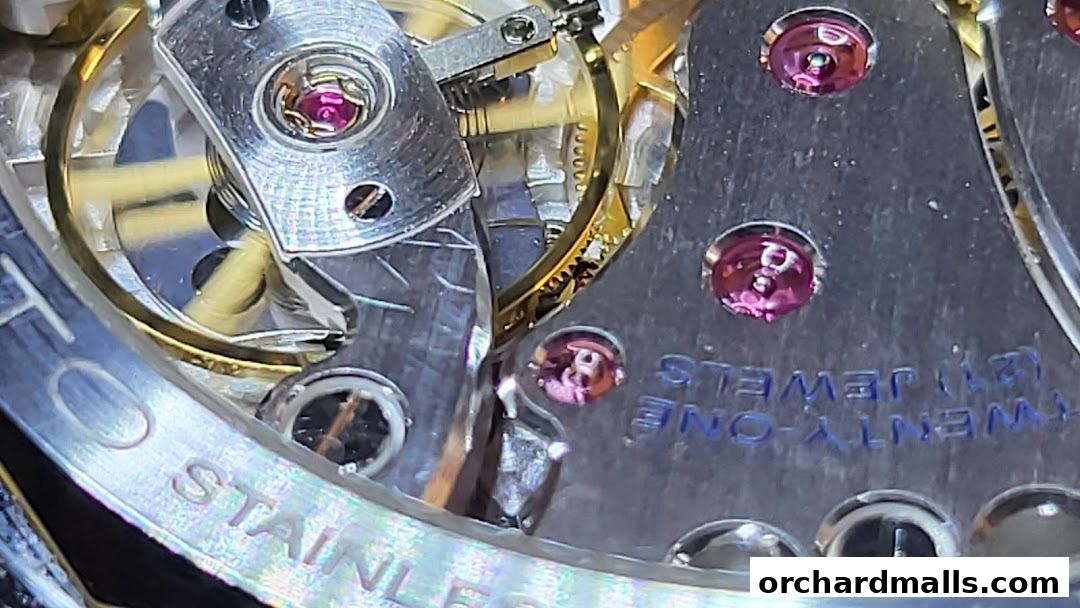 Close-up view of a watch movement with intricate gears and ruby jewels.