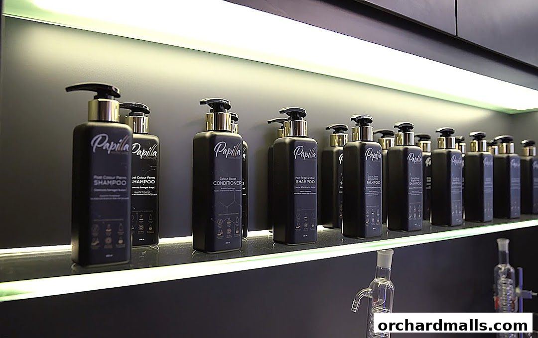 A display of Papilla By Kim Lim hair care products on shelves with lighting.
