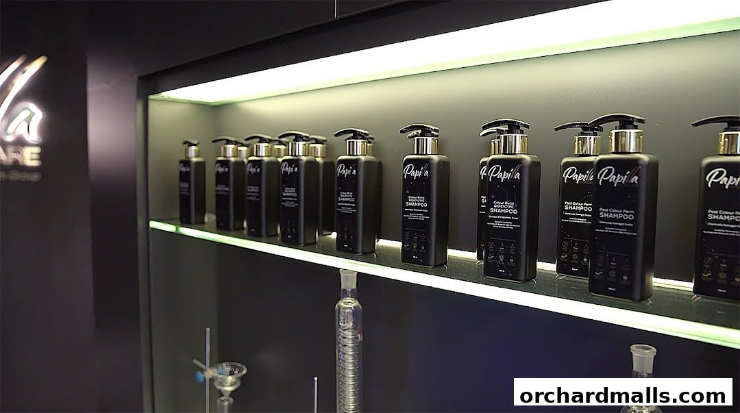 A display of Papilla By Kim Lim branded shampoos on a shelf with lighting.