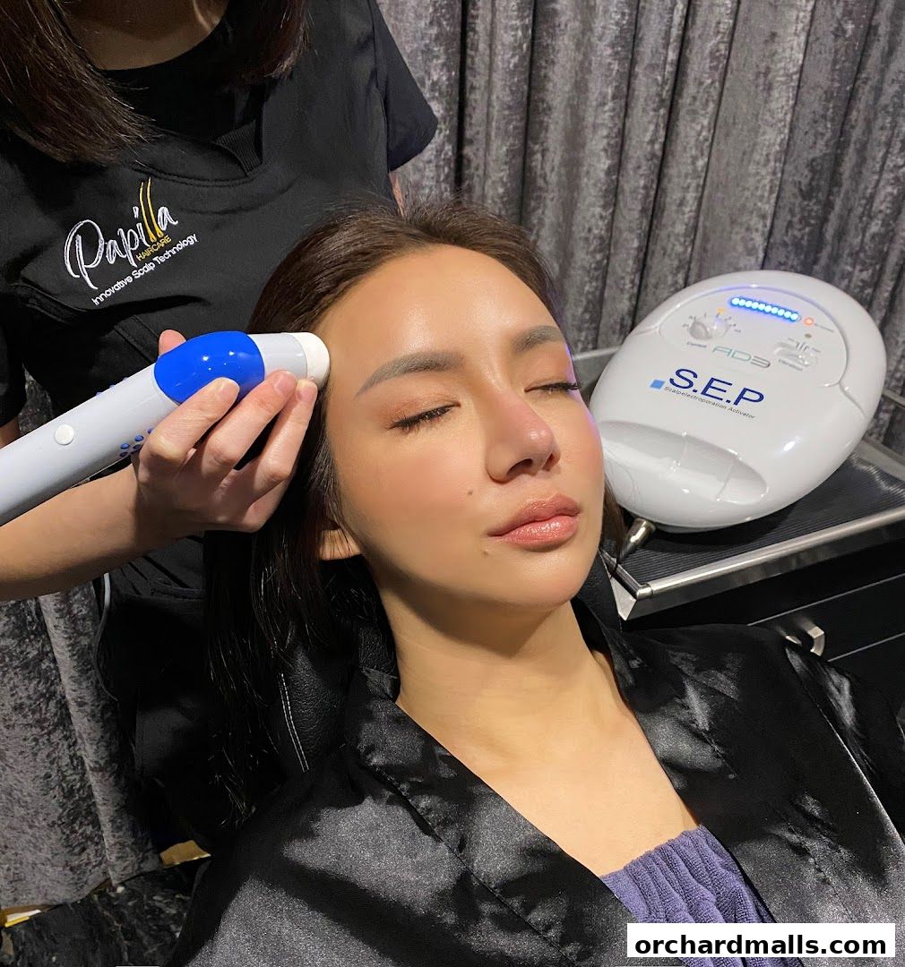 A woman receives a scalp treatment with advanced technology at Papilla By Kim Lim.