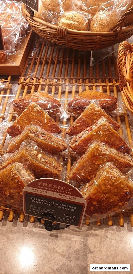 A display of freshly baked bread and pastries, with a focus on a chewy glutinous sandwich bread.