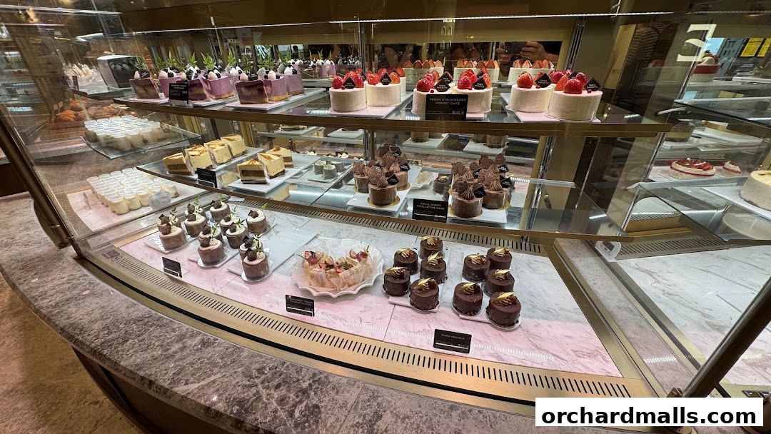 A display case filled with a variety of beautifully decorated cakes and pastries.