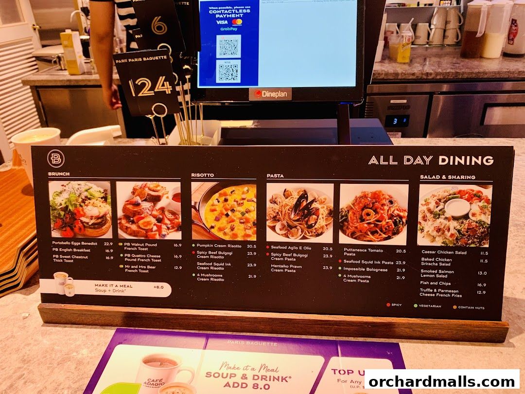 A menu board from Paris Baguette showcasing brunch, risotto, pasta, and salad options with enticing images.