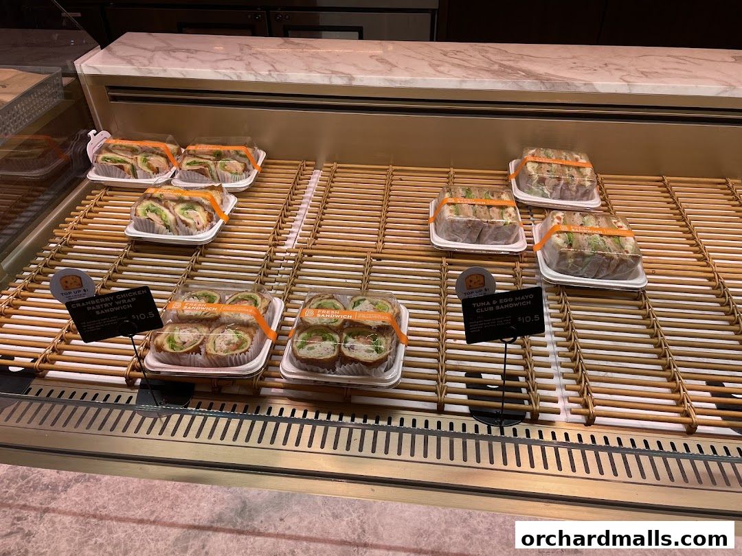 A display case filled with various pre-packaged sandwiches and wraps from Paris Baguette.