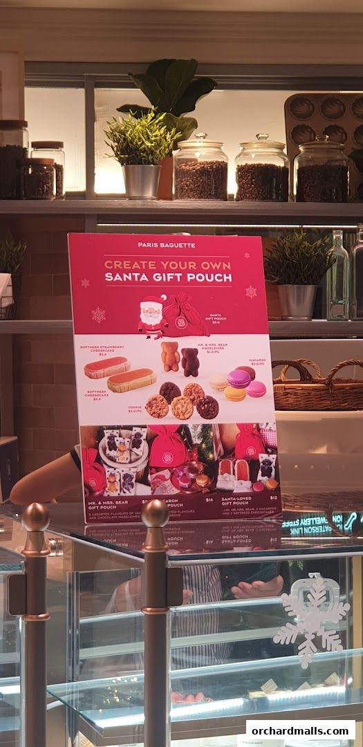 A promotional sign for Paris Baguette's 'Create Your Own Santa Gift Pouch' holiday offering.