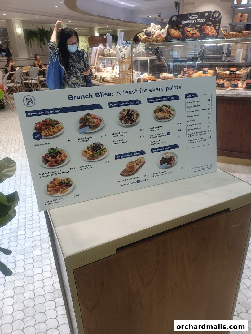 A menu board displays various brunch items, pasta, toast, and add-ons with prices.
