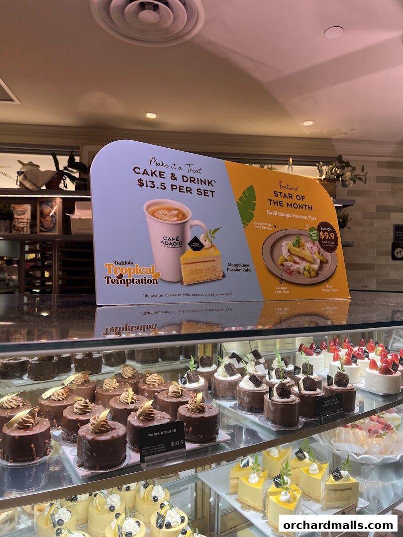A display case filled with various cakes and pastries at Paris Baguette.