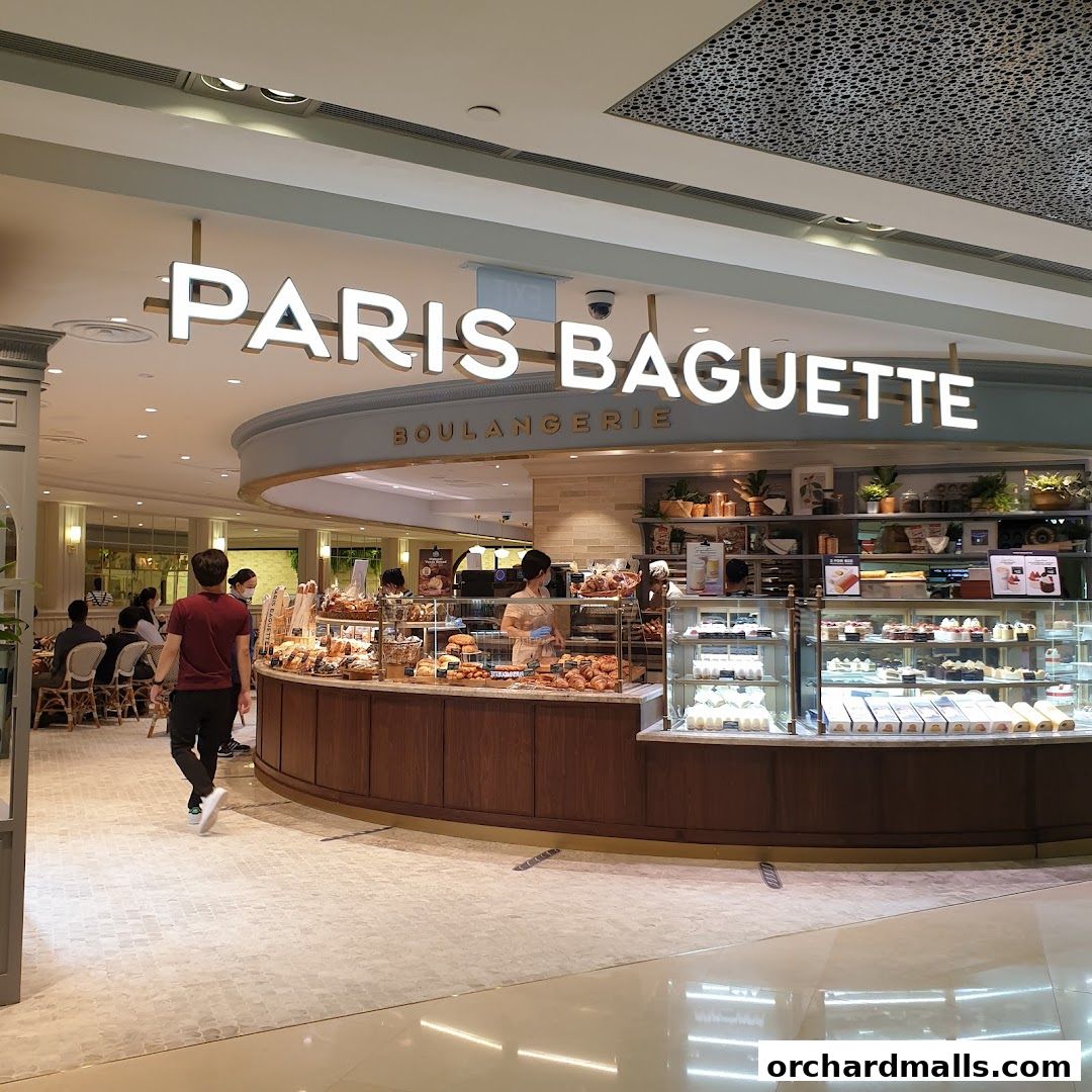 Paris Baguette boulangerie with a display of fresh pastries and cakes, and customers dining.