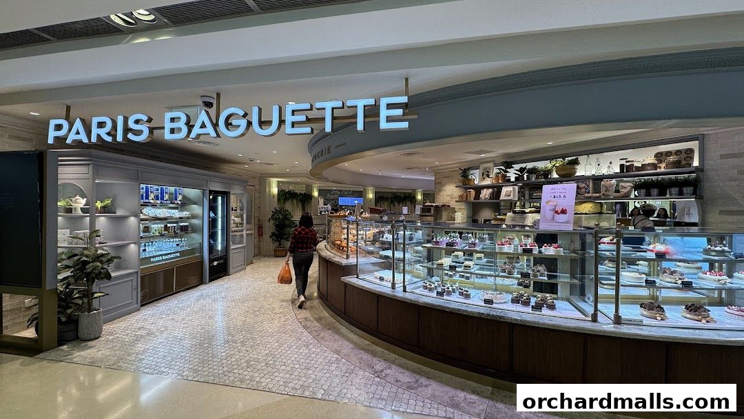 Paris Baguette shop interior showcasing a wide selection of cakes and pastries in display cases.