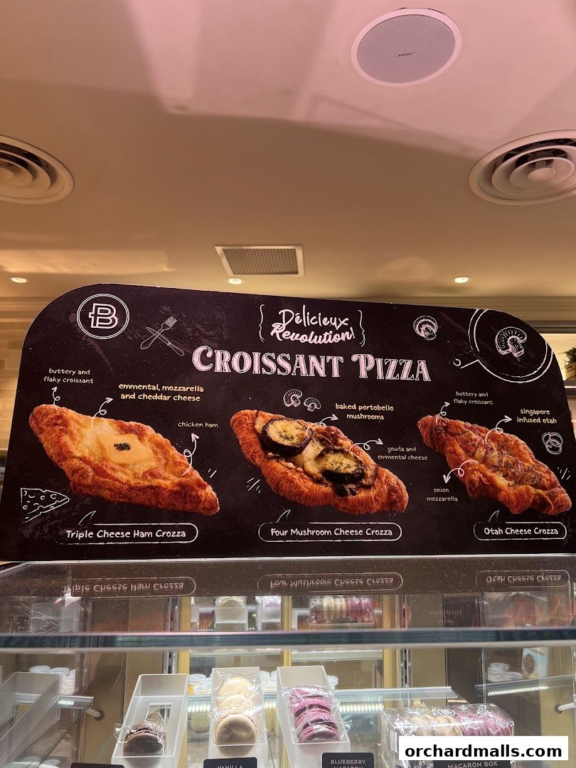 A display board showcasing three types of croissant pizzas with descriptions and ingredients.