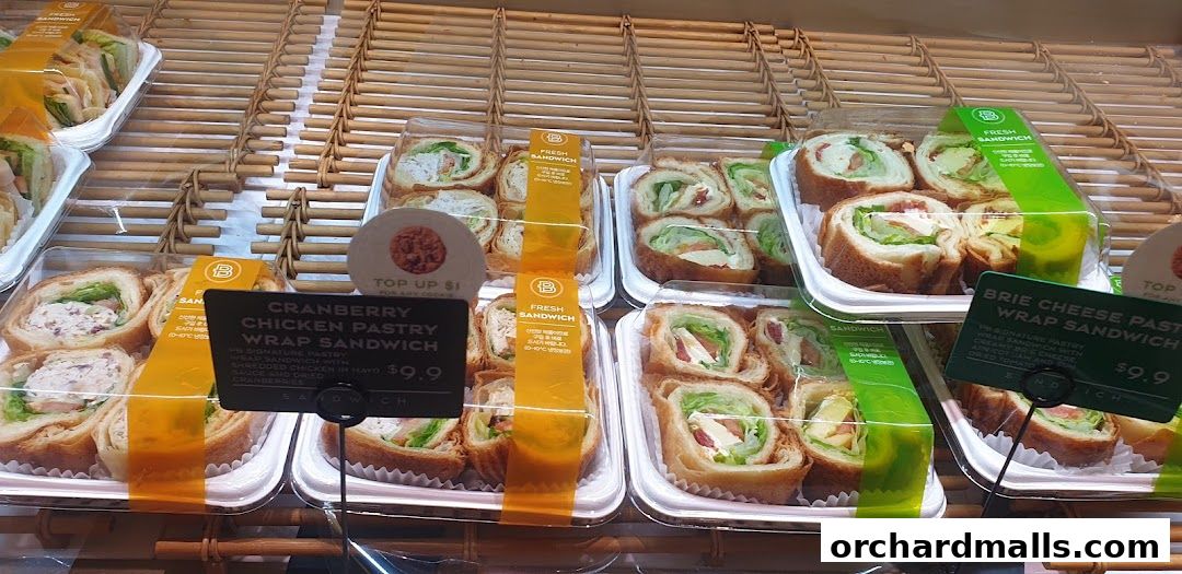 A display of fresh wrap sandwiches and pastries at Paris Baguette.