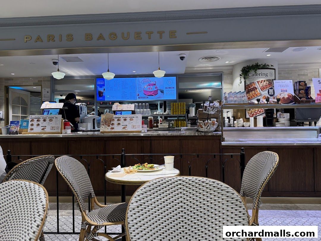 Interior view of Paris Baguette with seating, counter, and menu displays.