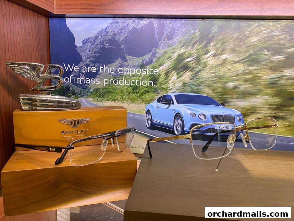 Bentley branded eyewear displayed with a Bentley car backdrop and emblem.
