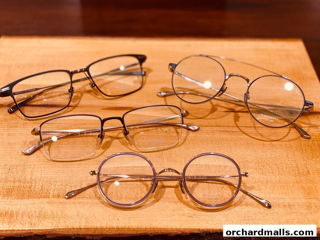 A collection of stylish eyeglasses displayed on a wooden surface.