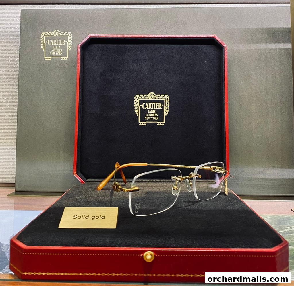 Cartier rimless glasses in a presentation box with 'Solid gold' label.