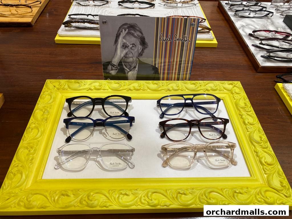 A display of various eyeglasses, including a prominent yellow frame showcasing three pairs.