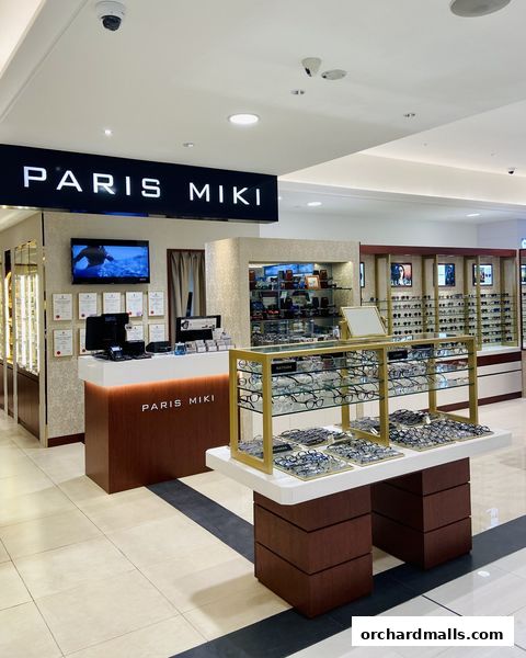 Interior view of a Paris Miki optical shop showcasing eyeglasses and a reception desk.