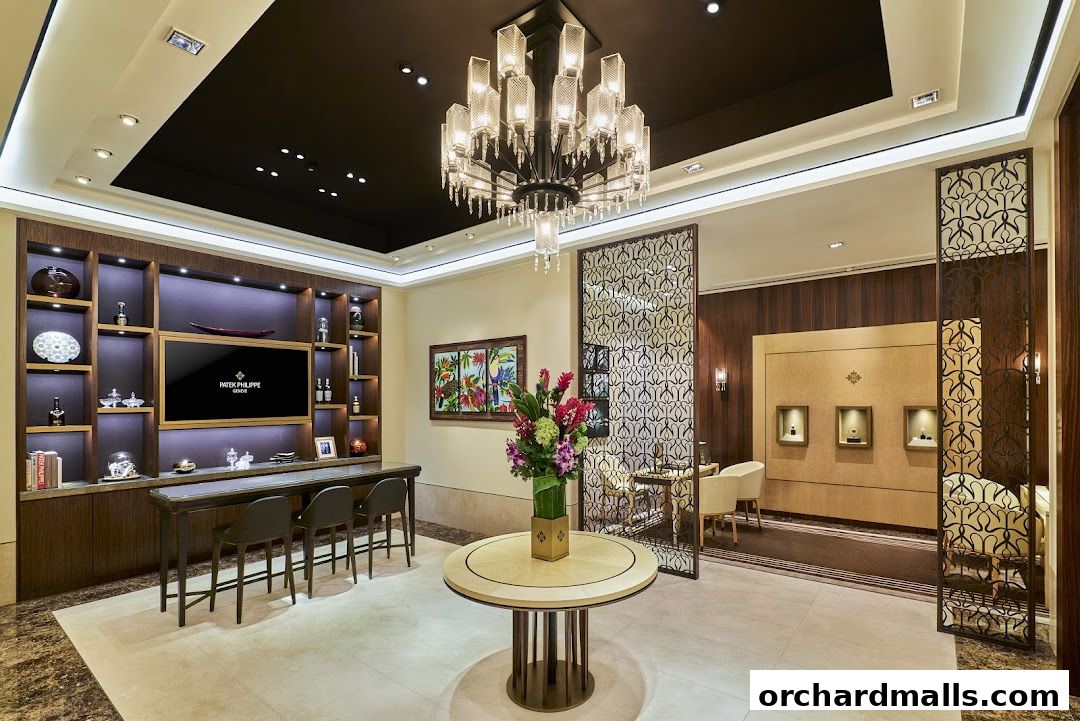 Interior of a luxurious Patek Philippe boutique with display shelves, seating, and a large chandelier.