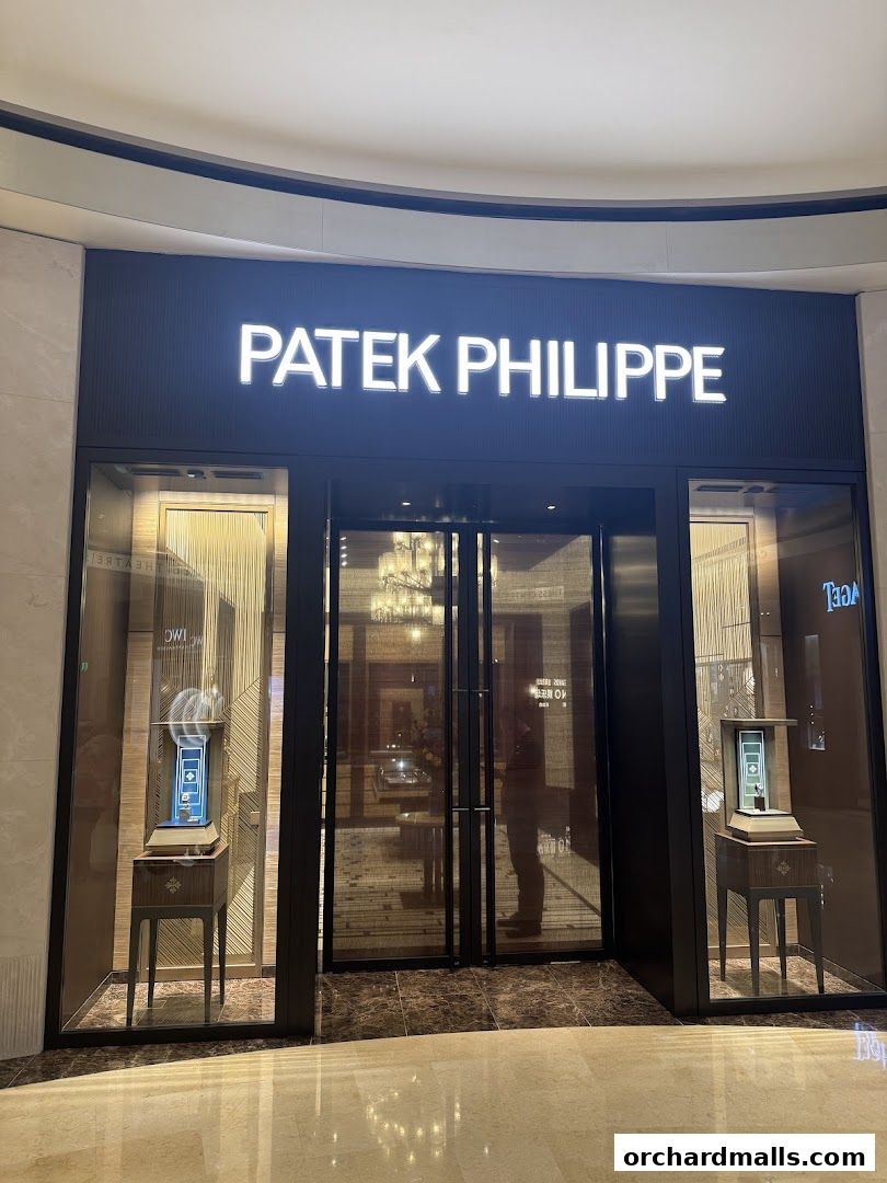 The elegant storefront of a Patek Philippe boutique, showcasing luxury watches in display windows.