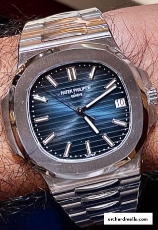 A close-up shot of a Patek Philippe watch with a blue dial and stainless steel bracelet.