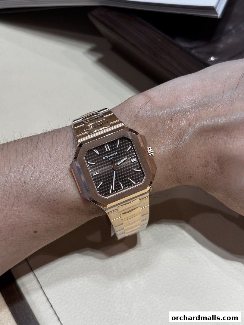 A close-up shot of a person wearing a rose gold Patek Philippe watch.