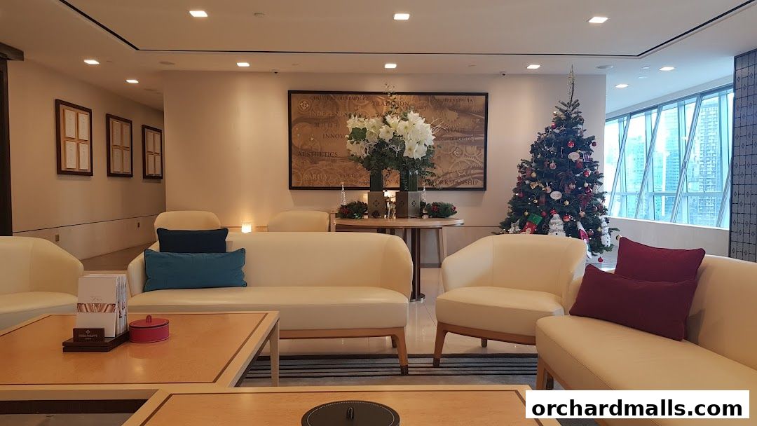 Luxurious waiting area with plush sofas, festive Christmas tree, and city views.