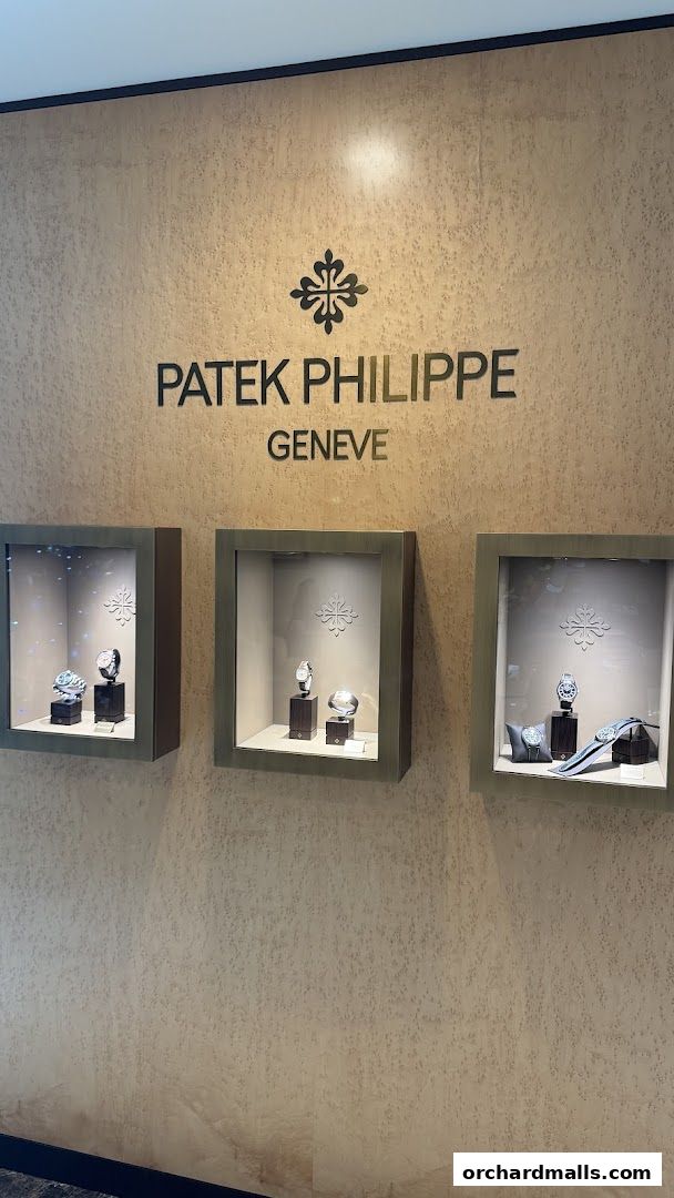 Patek Philippe Geneve logo above display cases showcasing luxury watches.