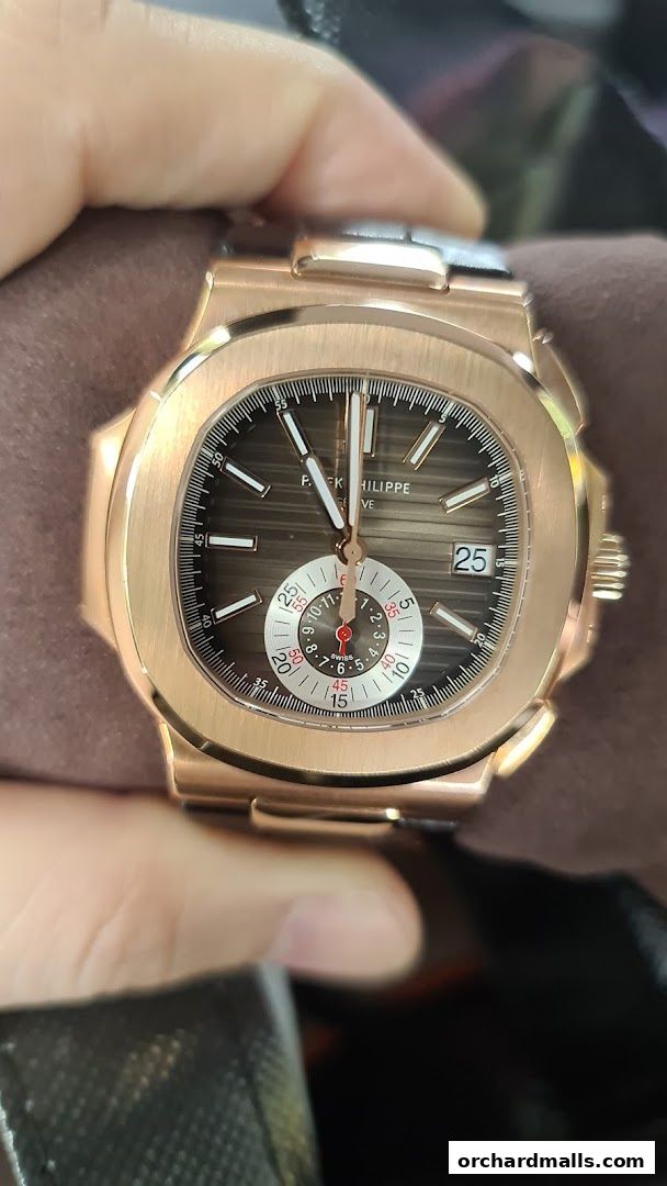 A close-up shot of a luxurious Patek Philippe rose gold watch with a detailed dial.