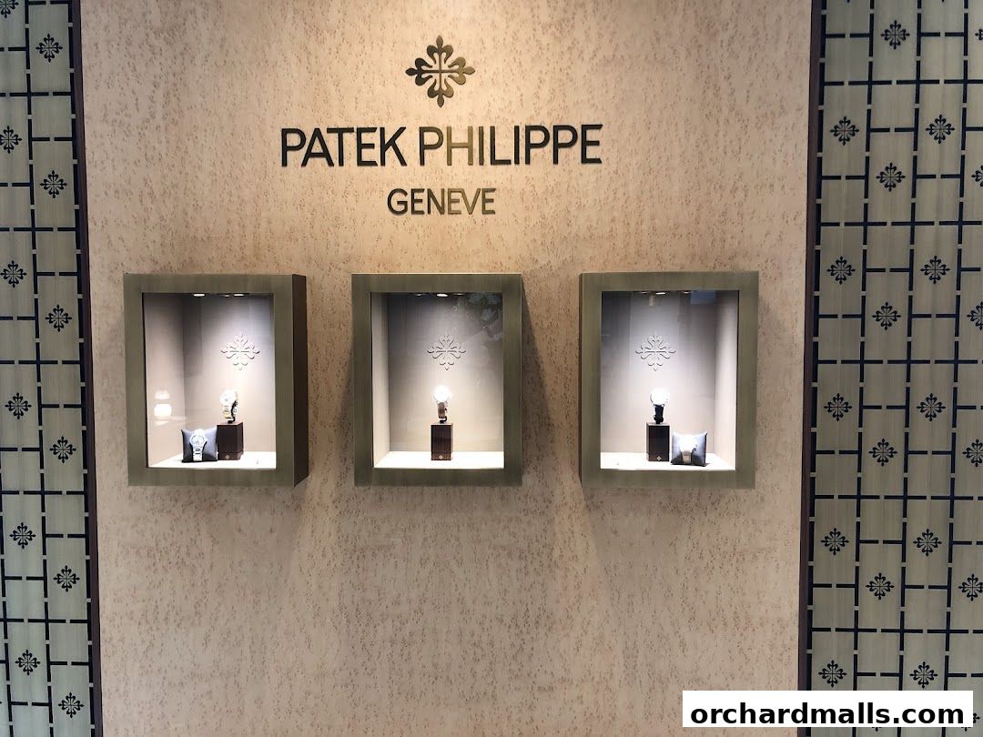 Patek Philippe Geneve display with three illuminated watch showcases.