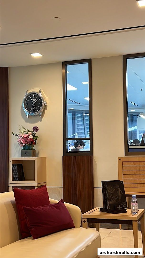 Interior of a Patek Philippe customer service center with a large clock and seating area.