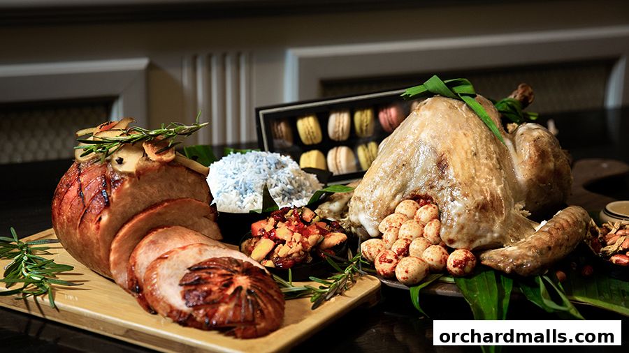A festive spread featuring a roasted turkey, sliced ham, rice, and macarons.