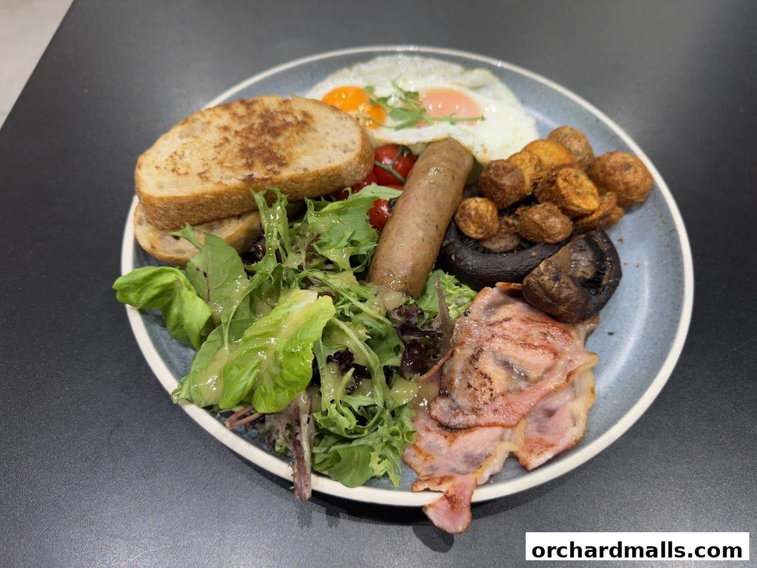 A hearty breakfast plate with eggs, sausage, bacon, toast, and salad.