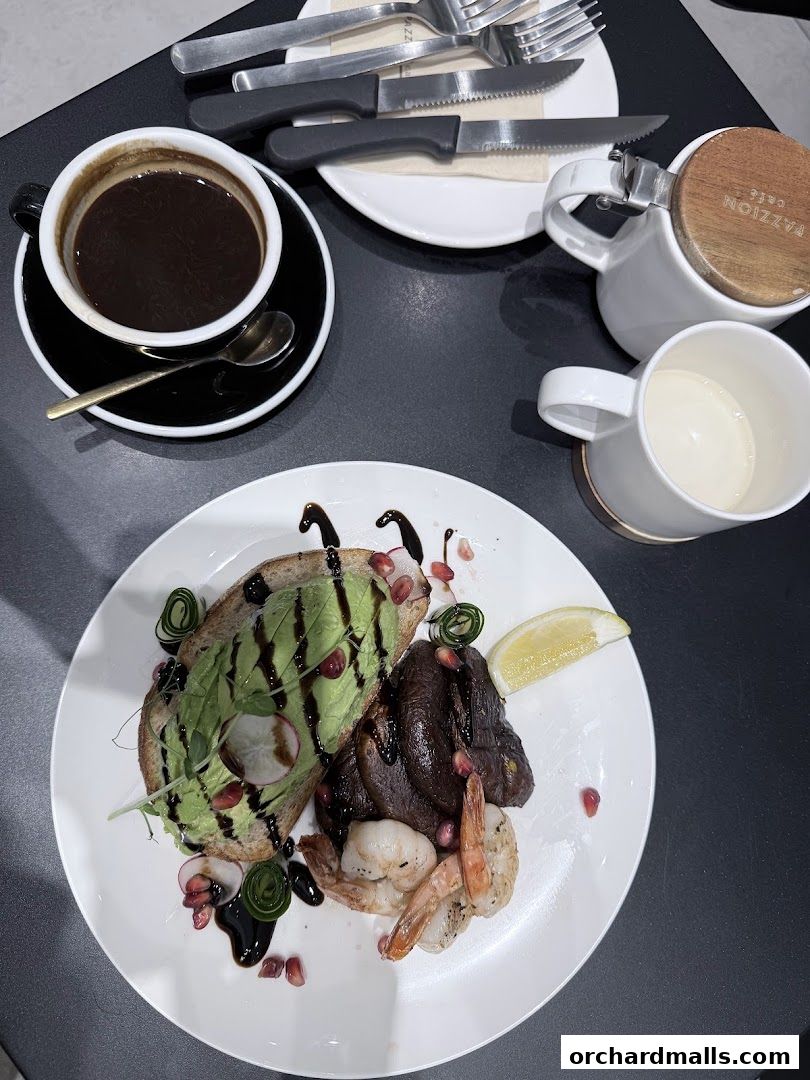 A plate of avocado toast with shrimp and a cup of coffee at Pazzion Cafe.