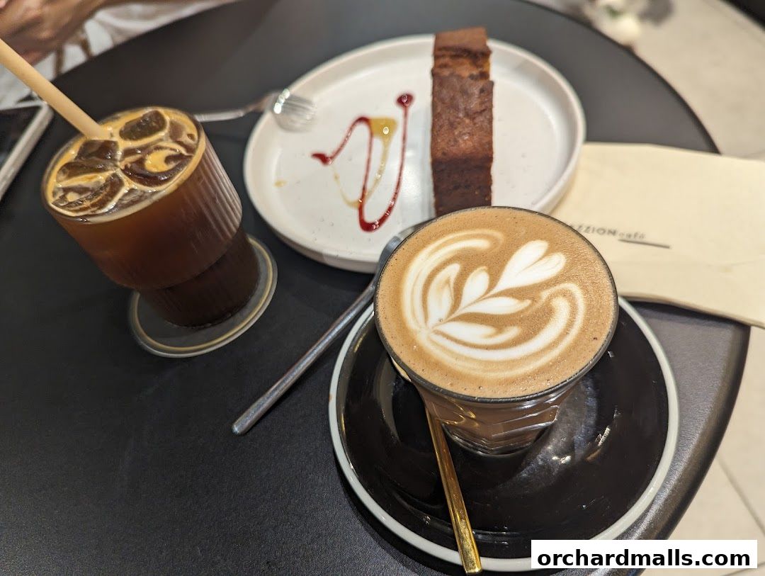 A close-up of coffee drinks and a slice of cake on a table.