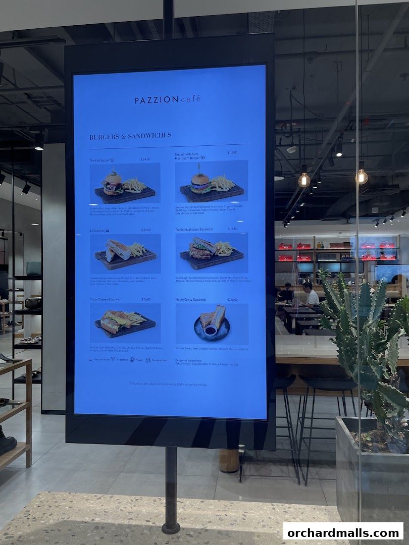 A digital menu board displays burgers and sandwiches from PAZZION Cafe.
