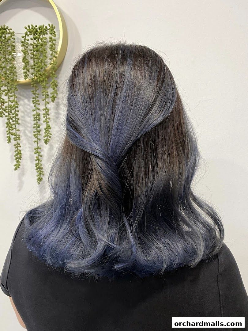 A person with stylish blue-grey ombre hair styled with a twist.