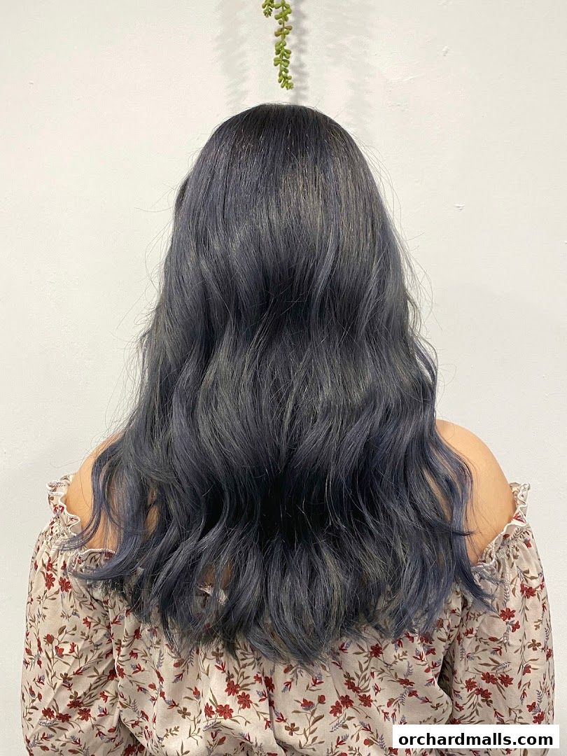 A person with wavy, dark grey hair styled by Peinto Salon.